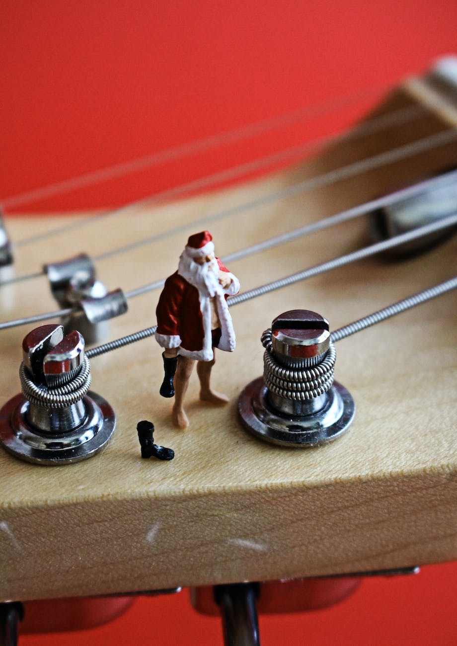 A model Santa standing on the head of a guitar neck.